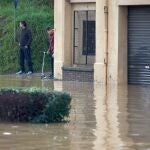 Unos vecinos observan el río Ter, que se ha desbordado a su paso por la ciudad de Girona, en el punto más bajo de su recorrido, junto a la carretera C-255, más allá del puente del Agua este miércoles. EFE/ David Borrat