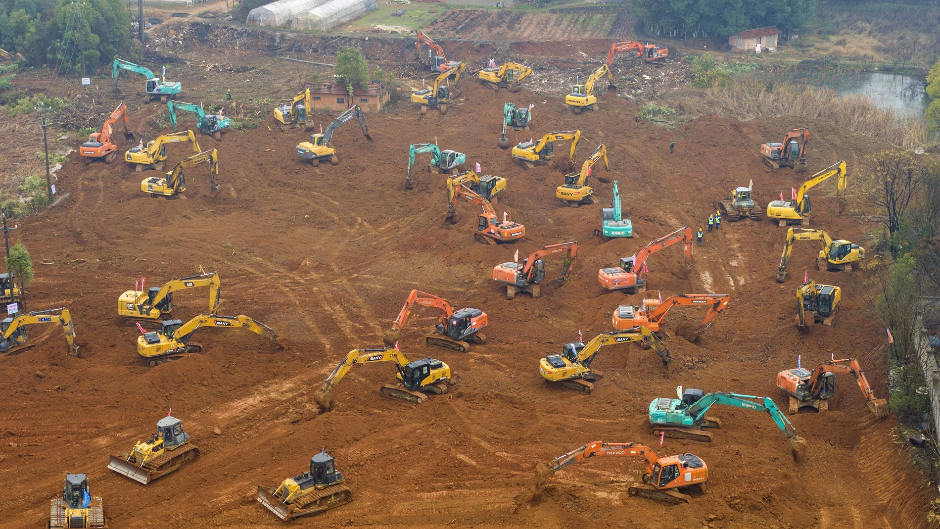 Decenas de excavadoras trabajan sin descanso para la construcción del nuevo hospital. (Chinatopix via AP)