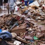 Vista de una calle abarrotada de objetos y deshechos de las casas, afectadas tras desbordarse ayer el río de Campanillas en el barrio del mismo nombre