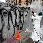 Un operario municipal elimina las pintadas de la Plaza del Dos de Mayo, en Malasaña, una de las zonas más afectadas