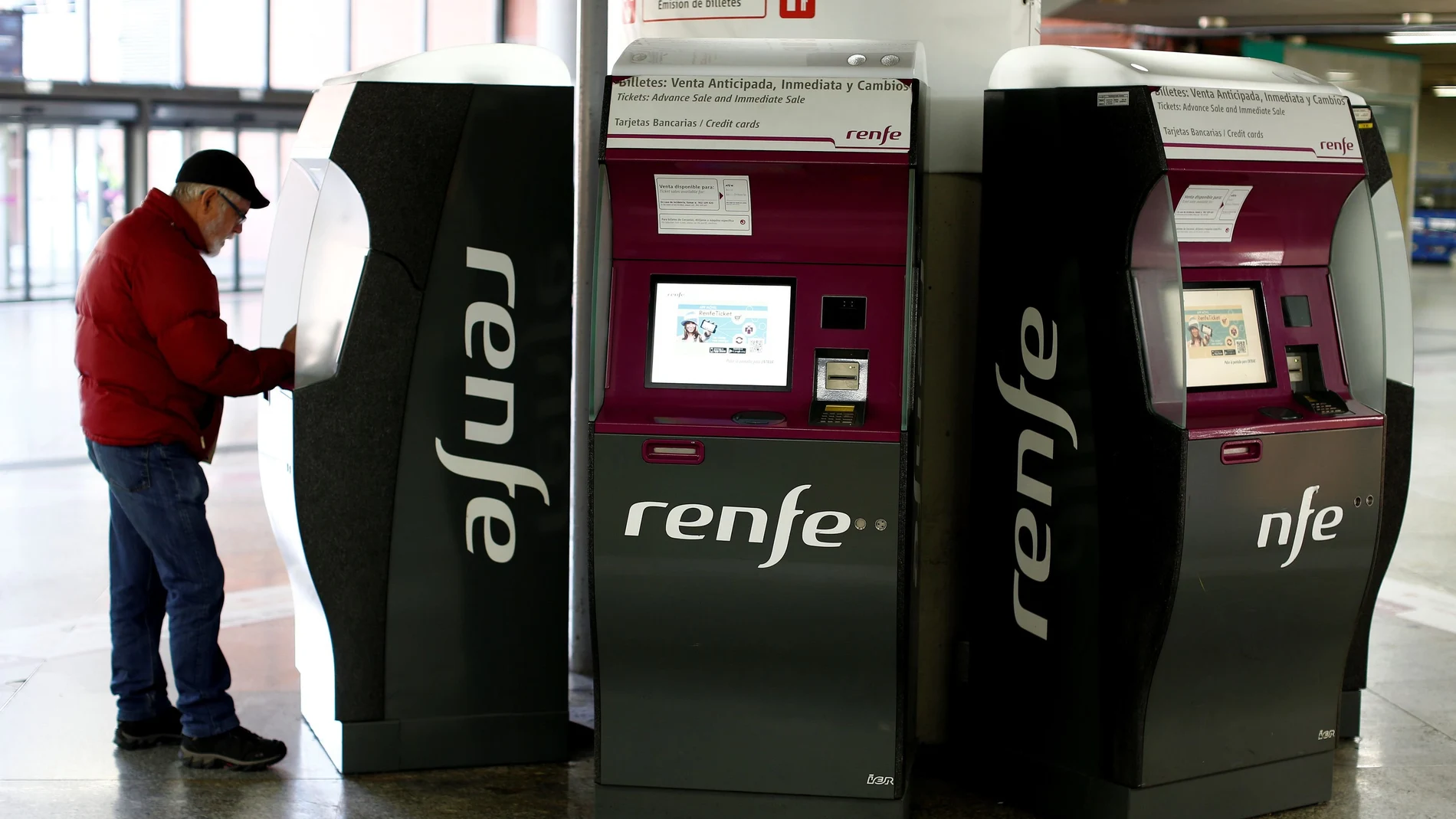 FILE PHOTO: A passenger uses an electronic ticket booth to purchase a Renfe train ticket at the Atocha train station in Madrid