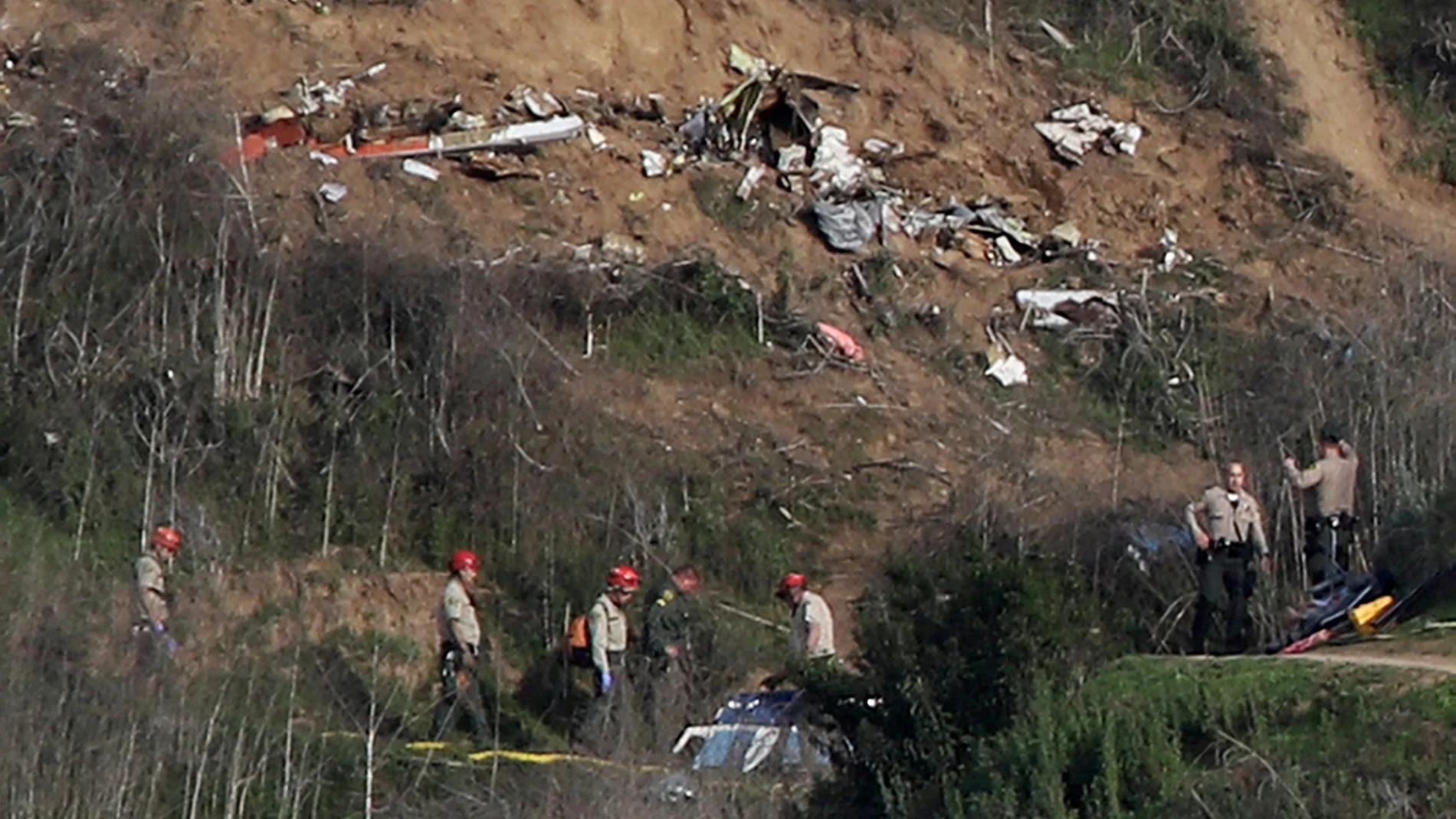 Sheriffs and officials investigate the helicopter crash site of NBA star Kobe Bryant in Calabasas, California