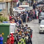 People line up to buy face masks from a medical supply company in Nanning in southern China's Guangxi Zhuang Autonomous Region, Wednesday, Jan. 29, 2020. Countries began evacuating their citizens Wednesday from the Chinese city hardest-hit by a new virus that has now infected more people in China than were sickened in the country by SARS. (Chinatopix via AP)