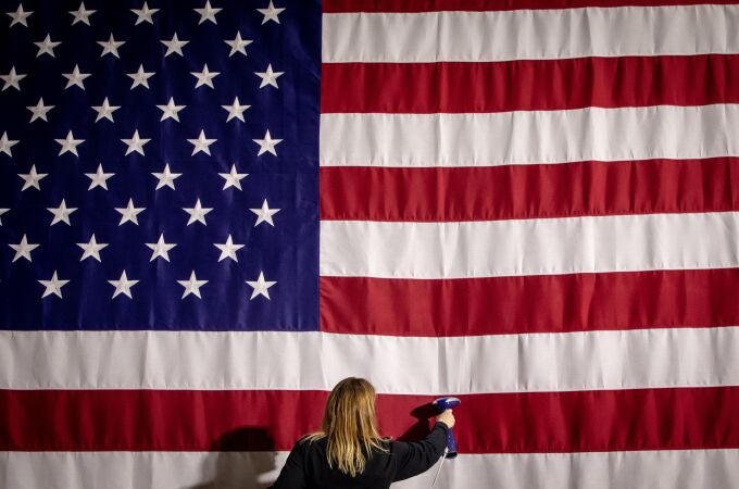 Imagen de una asistente planchando la bandera estadounidense en el Caucus de Iowa (EE.UU).