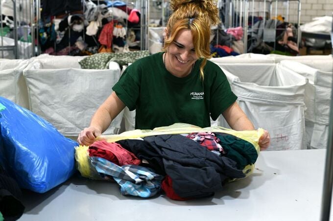 Una trabajadora selecciona las prendas para su posterior venta o para su reciclaje y fabricación de mantas, trapos u otros productos textiles.