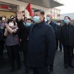 In this photo released by Xinhua News Agency, Chinese President Xi Jinping, centre, wearing a protective face mask waves as he inspects the novel coronavirus pneumonia prevention and control work at a neighbourhoods in Beijing, Monday, Feb. 10, 2020. China reported a rise in new virus cases on Monday, possibly denting optimism that its disease control measures like isolating major cities might be working, while Japan reported dozens of new cases aboard a quarantined cruise ship. (Pang Xinglei/Xinhua via AP)