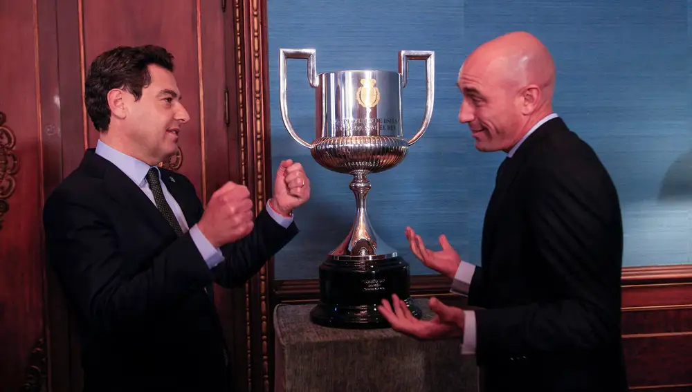 Rubiales, con el presidente de la Junta de Andalucía, Moreno Bonilla, y la Copa del Rey al fondo