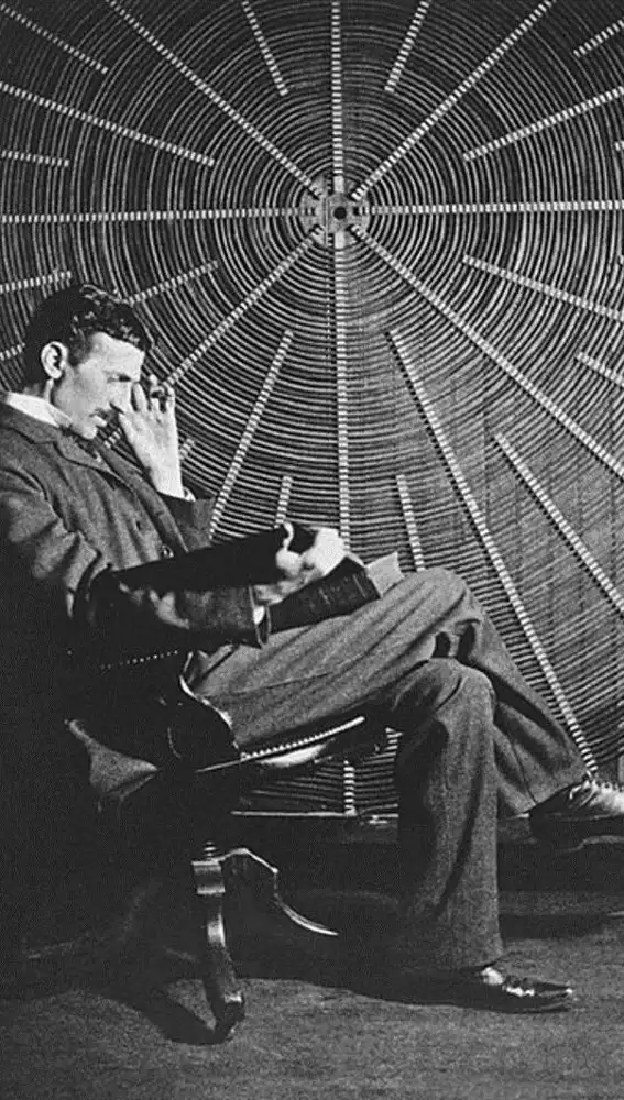 Nikola frente a una bobina de Tesla en su laboratorio de Nueva York, leyendo &quot;Theoria Philosophiae Naturalis&quot;
