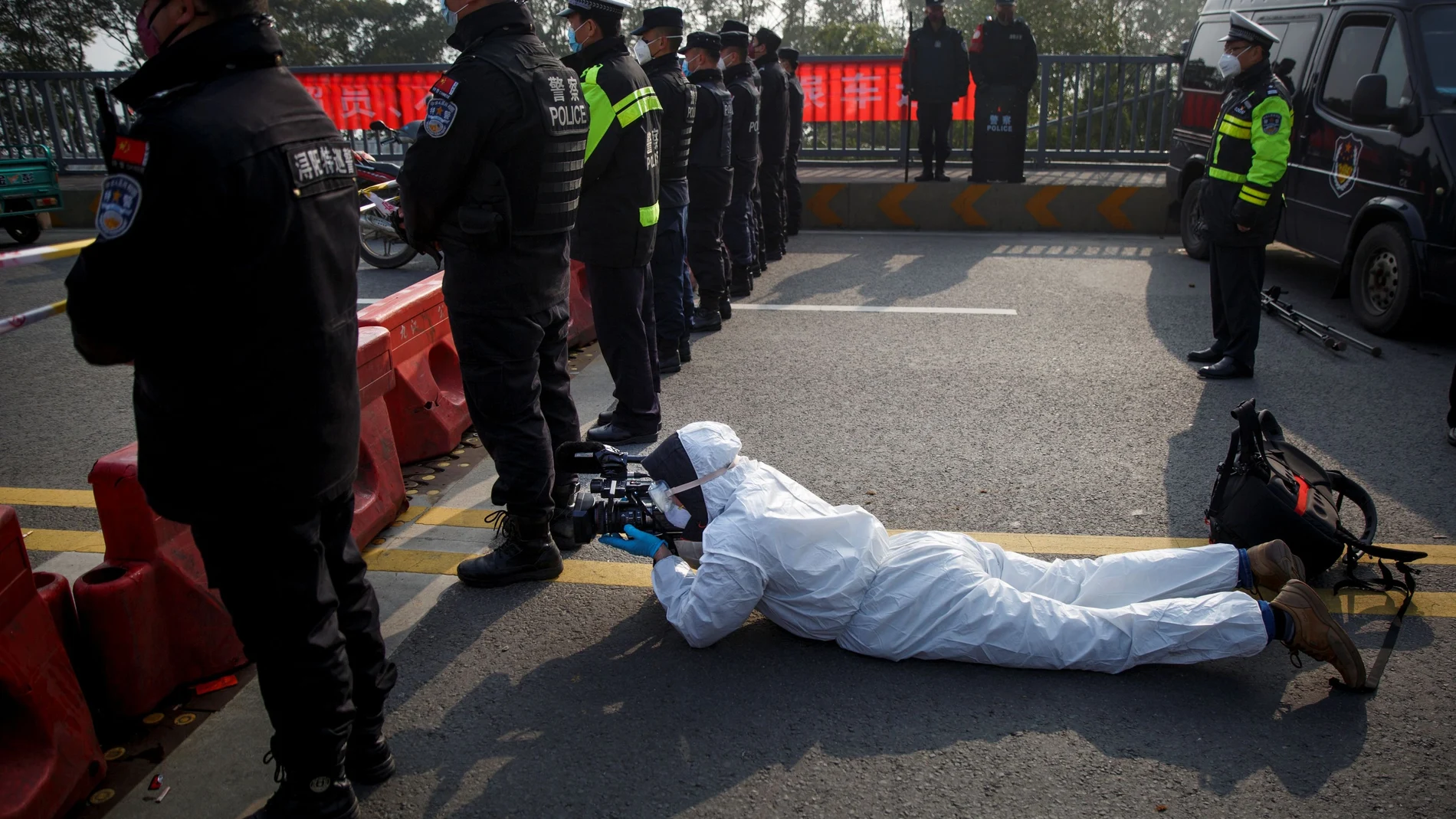 Reuters video journalist Martin Pollard wears a protective suit as he films at the Jiujiang Yangtze River Bridge in Jiujiang
