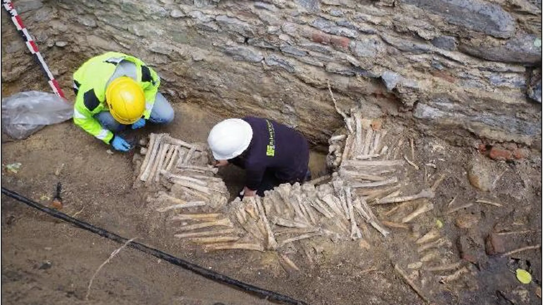 Dos arqueólogos trababan en los muros de huesos