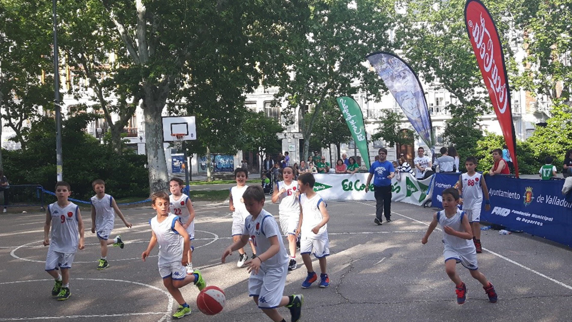 Varios niños juegan un partido de mini-basket