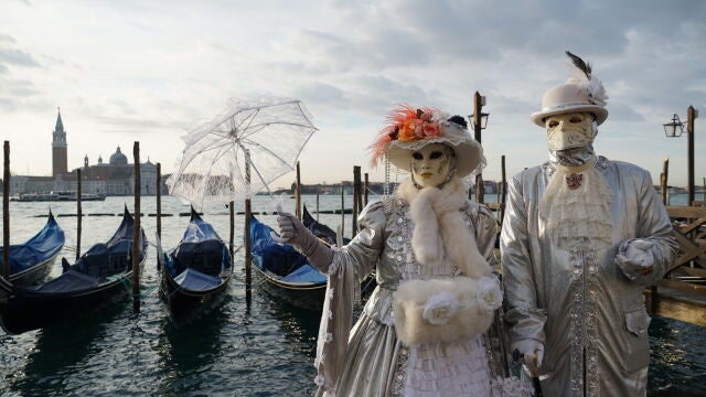 Una pareja posa enmasacarada en el embarcadero de la Plaza de San Marcos de Venecia/EPA