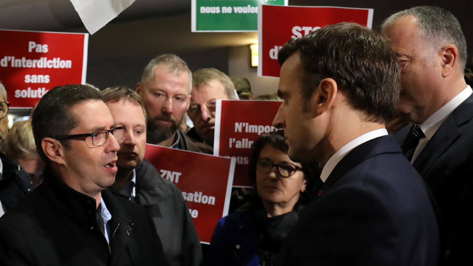 French President Emmanuel Macron talks with a member of the French farmers union FNSEA as he arrives at the 57th International Agriculture Fair (Salon international de l'Agriculture) at the Porte de Versailles exhibition center in Paris