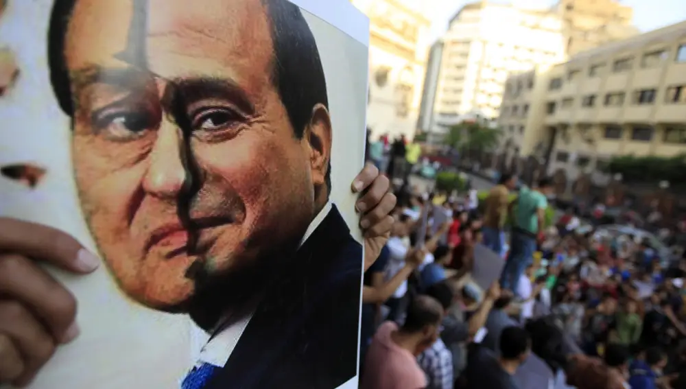A poster show a placard with the faces of Egypt's ousted President Hosni Mubarak (L) and presidential candidate and former army chief Abdel Fattah al-Sisi is seen by activists during a protest against sisi and a law restricting demonstrations as well as the crackdown on activists, in downtown Cairo May 24, 2014. Egyptians vote this week in an election expected to make former army chief Abdel Fattah al-Sisi president, marking a revival of strongman rule three years after the downfall of Hosni Mubarak. REUTERS/Amr Abdallah Dalsh (EGYPT - Tags: POLITICS CIVIL UNREST)