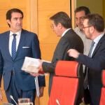 El consejero de Fomento y Medio Ambiente, Juan Carlos Suárez-Quiñones, dialoga con varios procuradores momentos antes de comparecer en las Cortes