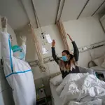 Un sanitario enseña a una paciente ejercicios mientras se recupera en un hospital de Wuhan.