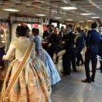 Un grupo de falleras se disponen a subir al metro en Valencia