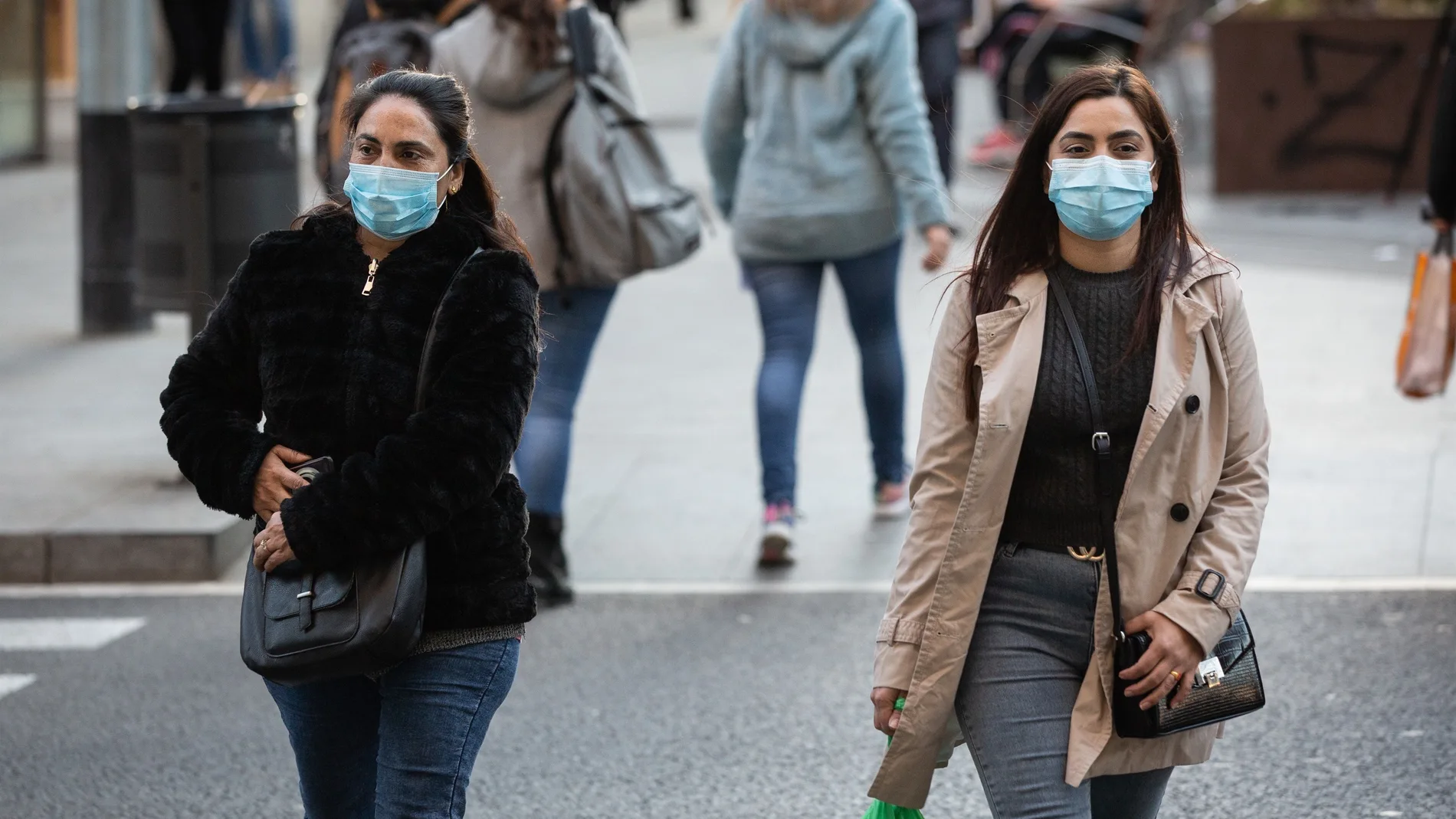 Dos mujeres pasean con mascarilla por el brote de coronavirus