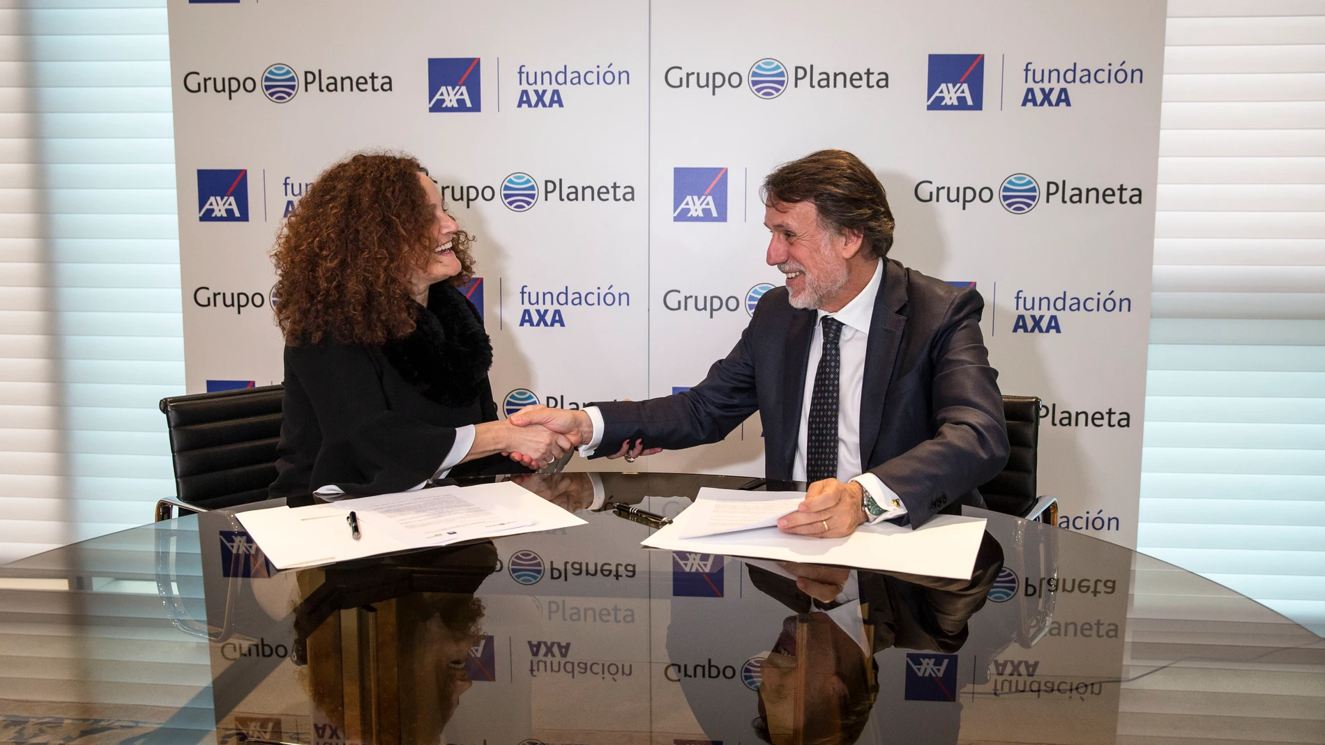 Olga Sánchez, presidenta de la Fundación AXA, y José Creuheras, presidente del Grupo Planeta, tras la rúbrica del acuerdo