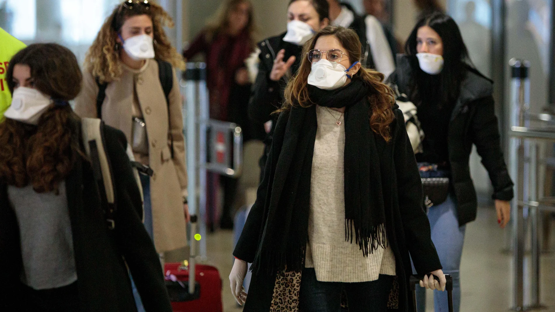 Viajeros procedentes de Italia protegidos con mascarillas a su llegada al aeropuerto de Manises (Valencia). Foto: Efe