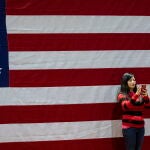 Una seguidora de Joe Biden se hace un selfie con la bandera de EE UU en Virginia