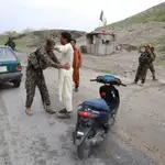 Oficiales de seguridad afganos revisan a un conductor