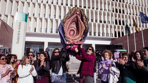Un grupo de mujeres portan una reproducción de una vagina gigante ante la Audiencia de Málaga antes del inicio del juicio