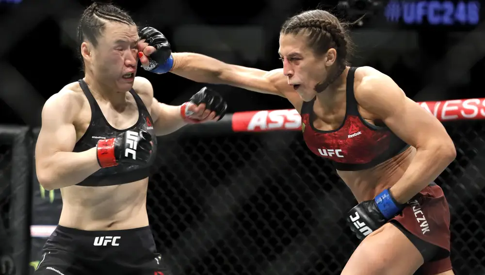 UFC women's strawweight champion Weili Zhang, left, of China, takes a punch from former champion Joanna Jedrzejczyk of Poland during UFC 248 at T-Mobile Arena in Las Vegas Saturday, March 7, 2020. (AP Photo/Las Vegas Sun/Steve Marcus)/Las Vegas Sun via AP)