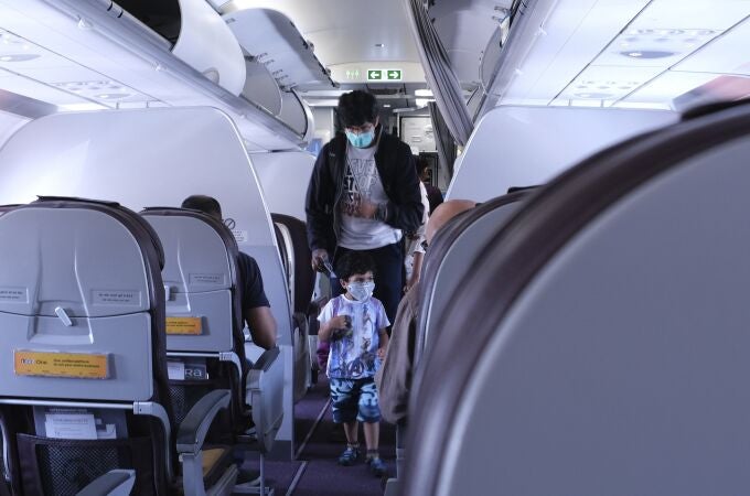 Un pasajero y su hijo con mascarillas en un vuelo de Sri Lanka