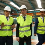 El consejero de Empleo e Industria, Germán Barrios (C), junto al director general de Tvitec, Javier Prado (I), durante la visita las instalaciones de la empresa en Cubillos del Sil (León)