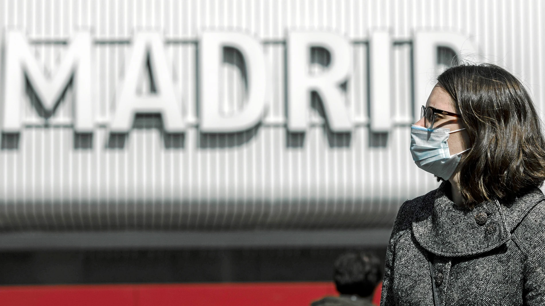 Una mujer camina protegida con una mascarilla en Madrid