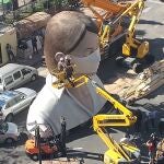 Los artistas de la falla municipal, con la "plantà" detenida, provecharon para ponerle una mascarilla a la figura principal.