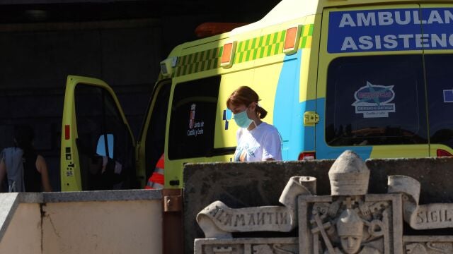 Una mujer con mascarilla pasa por delante del Hospital Clínico de Salamanca, donde ha fallecido una persona en las últimas horas por Covid-19