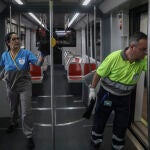 Dos trabajadores limpian los pasamanos y barandillas del metro de Sevilla