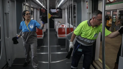 Dos trabajadores limpian los pasamanos y barandillas del metro de Sevilla