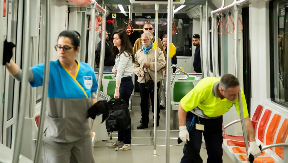 Unos operarios desinfectan pasamanos y agarraderos de los vagones en una de las terminales del metro de Sevilla como medida de seguridad frente a la pandemia del coronavirus