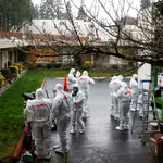 Un equipo de limpieza se pone el traje de protección antes de entrar en un centro de Kirkland (Estados Unidos) donde son tratados varios pacientes de coronavirus