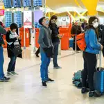 Viajeros protegidos con mascarillas este jueves en el aeropuerto Madrid-Barajas Adolfo Suárez