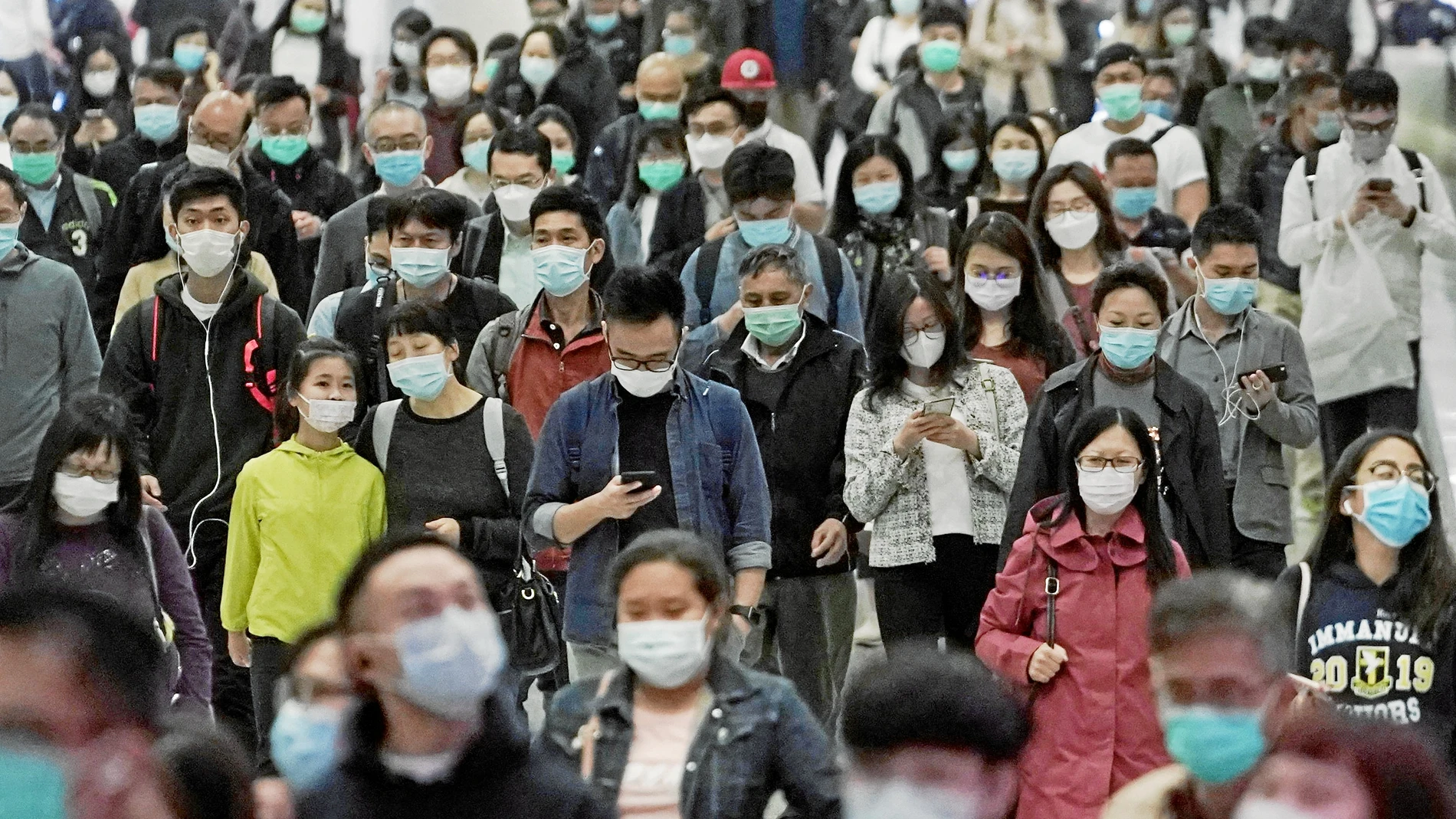 Un grupo de ciudadanos chinos con mascarilla como precaución para evitar el contagio
