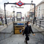 Un joven sale del Metro de la Estación Sol con mascarilla como medida de protección frente al Coronavirus