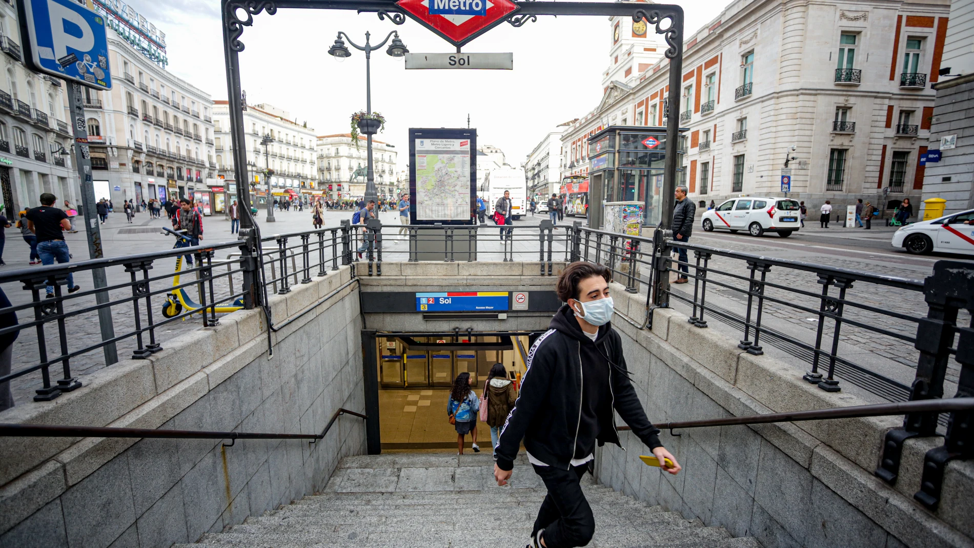 Un joven sale del Metro de la Estación Sol con mascarilla como medida de protección frente al Coronavirus
