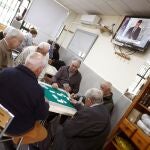 Un grupo de ancianos juega al mus en un bar del barrio de Aluche, en Madrid