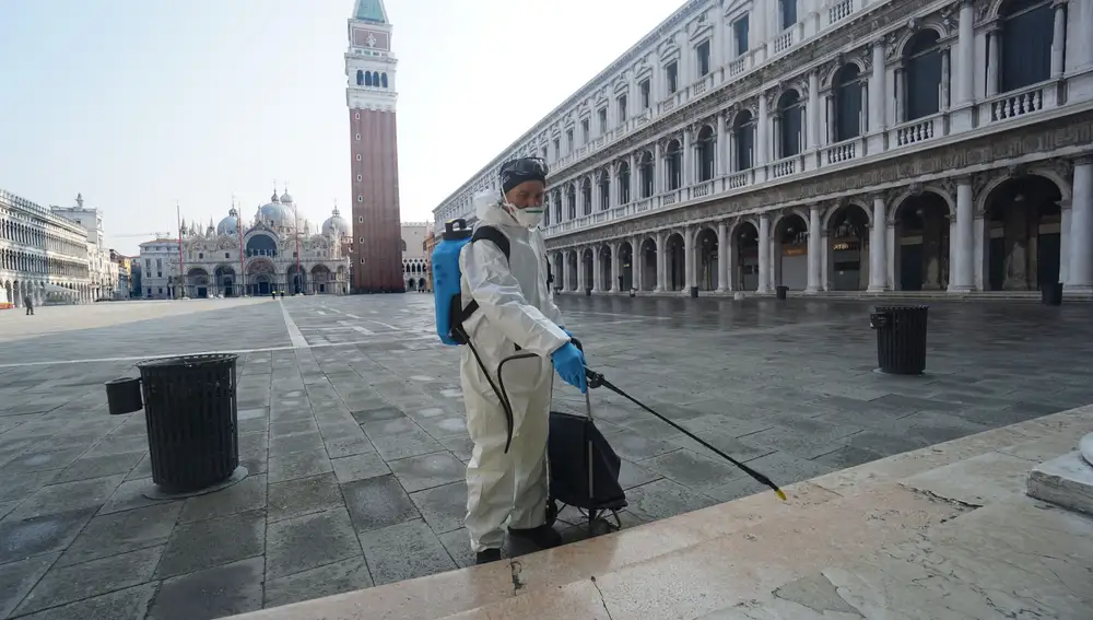 Venecia, Italia, 12/03/2020.- Un empleado sanitario desinfecta una conocida plaza de Venecia.