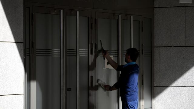 Un trabajador limpia los cristales de la sede de la Audiencia Nacional durante la crisis del coronavirus