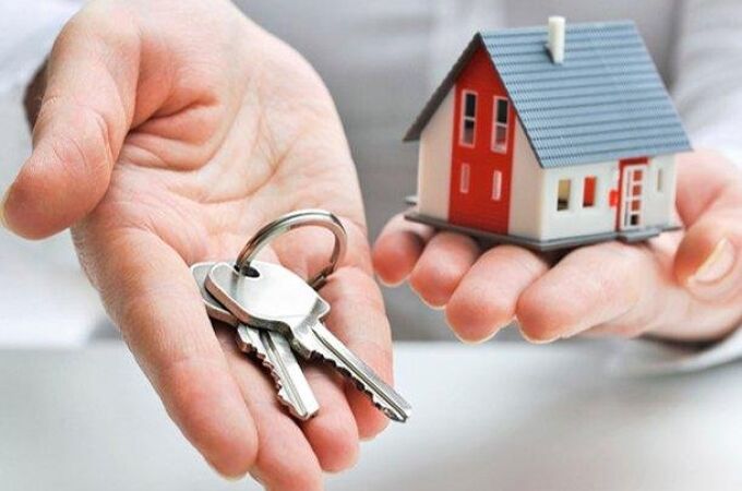 Una persona sostiene unas llaves y una casa