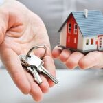 Una persona sostiene unas llaves y una casa