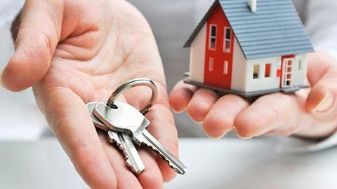 Una persona sostiene unas llaves y una casa