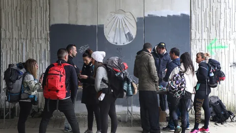 Un grupo de peregrinos que realizan el camino Francés realizan una parada para descansar