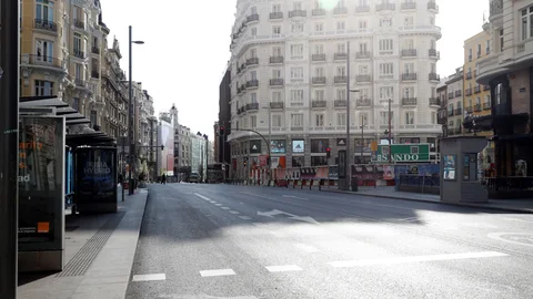 Vista inusual de la Gran Vía en Madrid prácticamente desierta, este domingo, tras el Real Decreto que establece las medidas del estado de alarma para hacer frente a la pandemia del Covid-19.