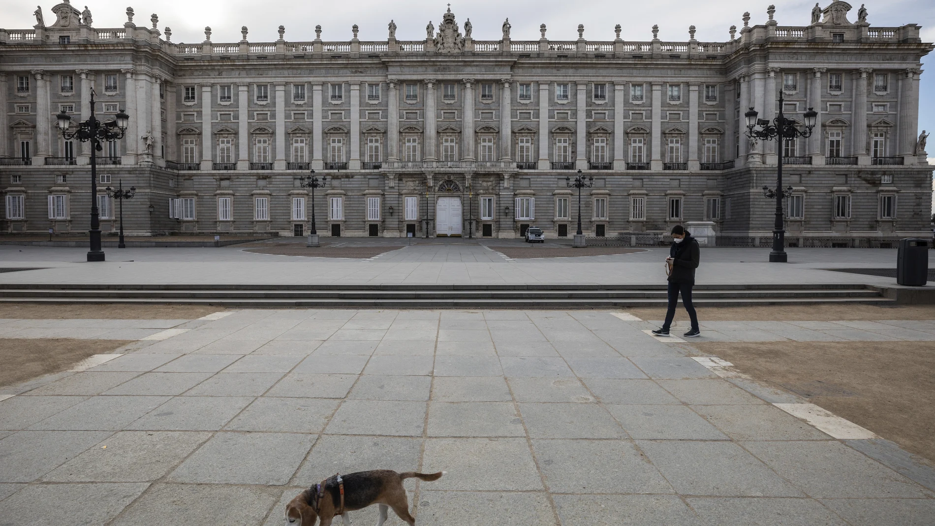 A woman walks her dog around the Royal palace in downtown Madrid, Spain, Sunday, March 15, 2020. Spain awoke to its first day of a nationwide quarantine on Sunday after the government declared a two-week state of emergency. The government imposed the special measures including the confinement of people to their homes unless shopping for food and medicine, going to and from work, and to meet other basic needs. The vast majority of people recover from the new coronavirus. According to the World Health Organization, most people recover in about two to six weeks, depending on the severity of the illness. (AP Photo/Bernat Armangue)
